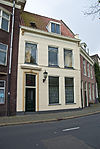 Witgepleisterd pand met omlijsteingang18703 -  licht geel gepleisterd pand met omlijste ingang aan Turfsingel 23 (niet 21) in Groningen. 
