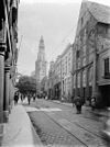 Straatbeeld met zicht op toren - Groningen - 20092975 - RCE -  Der Aa-Kerk, Groningen, straatbeeld met zicht op toren (rm 18424), 1926. Rechts het Gotische huis (rm 18433). In: Buiten, 20 (1926), nr. 15, p. 174. 