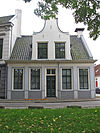 Groningen Turfsingel 45.JPG -  Groningen, Turfsingel 45; 18de eeuw; Pand zonder verdieping onder dwars zadeldak, waarvoor grote Vlaamse top met halsgeveltje en twee vensters. Ingang omlijst; vier zesruitsvensters. In de zijtop twee 12-ruitsvensters; rm 18705 