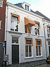 Wit gepleisterd pand met omlijste vensters