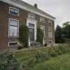 Overzicht van voorzijde woonhuis met entree