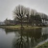 Overzicht met omgrachting en met links het woonhuis en rechts het bedrijfsgedeelte