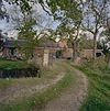 Rechter zijgevel van de schuren met oprijlaan met hekpijler - 't Zandt - 20347659 - RCE -  Boerderij Omtadaburgh: Rechter zijgevel van de schuren met oprijlaan met hekpijler 