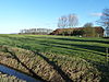 Midwolda - Ol Kerke - kerkplaats van rechts -  Ol Kerke. Plaats waar vroeger de Kruiskerk van Midwolda stond. Op de achtergrond een zwaar vervallen schuur en rechts het huis 'Ol Kerke'.