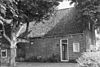 Grote boerderij met voorhuis onder zadeldak tussen afgeknotte topgevels (sinds 1977: gemeentehuis)