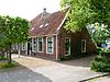 Den Ham - Ds. Koppiusweg 2 (1) -  Pand met voorhuis onder zadeldak (voormalig winkelpand) aan de Ds. Koppiusweg 2 in Den Ham (Groningen, Nederland). 