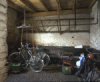 Interieur, overzicht van de voormalige paardenstal, met ruif, grote natuurstenen drinkbak en de originele klinkervloer
