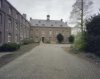 Overzicht van de binnenzijde van een vleugel van het complex met dakkapellen en een torentje met klok