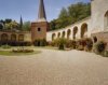 Overzicht van de binnenplaats met de ringmuur met spaarbogen en een hoektoren