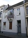 Huis met lijstgevel, gepleisterd en met moderne erker. Ankers A 16.. .