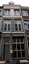 Huis met smalle voorgevel, eindigend in een hoofdgestel met consoles.