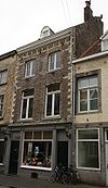 Huis, met eenvoudige lijstgevel, voorzien van hoekblokken en segmentboogvensters.