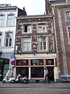 Huis met lijstgevel en gevelsteen met IHS boven een vlammend hart.