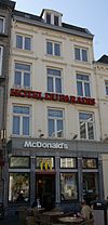 Huis met lijstgevel, met vensters in hardsteen en verticale reliefbanden.