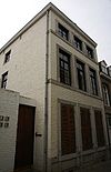 Huis met gepleisterde lijstgevel; zijgevel van mergel.
