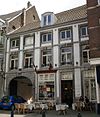 Huis met lijstgevel, voorzien van vensters in Naamse steen en met een rondbogige koetspoort.
