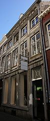 Huis, waarvan de voorgevel, eindigt in een hoofdgestel met consoles.