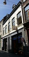 Huis met brede lijstgevel en gevelsteen met zon.
