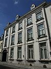 Huis met statige brede gevel in Lodewijk XVI-stijl met hoekrisalieten, die geaccentueerd zijn door geblokte lisenen.