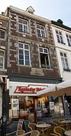 Huis met lijstgevel in de trant der zgn. Maaslandse renaissance. Gevelsteen met leeuw en vijzel IN DE GOUDEN LEEUW, afkomstig van Spilstraat 5.
