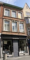 Huis met lijstgevel, voorzien van hardstenen segmentboogomramingen. De winkelpui is voorzien van gietijzer.