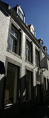Huis met lijstgevel, voorzien van omblokte vensters, waarvan de kruisen zijn uitgebroken.