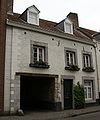 Huis met lijstgevel. Over de Jeker een gemetselde boogbrug.