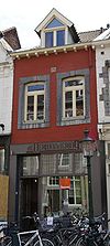 Huis met lijstgevel, voorzien van segmentboogvensters in Naamse steen.