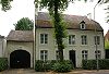 Statig huis onder zadeldak met brede voorgevel.