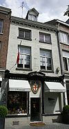 Huis met smalle lijstgevel, met mergelbanden en een hoofdgestel met consoles.