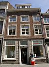 Huis met lijstgevel, voorzien van segmentboogvensters in Naamse steen.