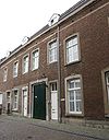 Huis waarvan de lijstgevel een geheel vormt met die van het nr 2. Nr 6 met koetspoort en een garageingang