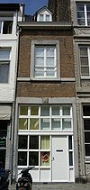 Gebouwtje met lijstgevel, voorzien van een rechthoekige koetspoort in een omlijsting van Naamse steen met diamantkopsluitsteen.
