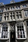 Huis met een voorgevel van hardsteen, eindigend in een hoofdgestel met consoles.