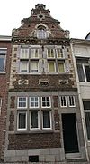 Huis, met aan de straat een in- en uitgezwenkte top in de trant van Hans Vredeman de Vries boven een Maaslands hoofdgestel met consoles.
