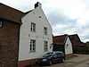 Hoeve met binnenplaats, van baksteen. Gepleisterde puntgevel