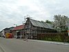 Hoeve om open binnenplaats van baksteen en vakwerk. In het vakwerk aan de binnenplaats ingang met in- en uitgezwenkte bovendorpel