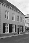 Groot hoekhuis met schilddak. Brede gepleisterde lijstgevel met hoeklisenen een met snijwerk versierde ingang met gesneden deur en snijraam in late Lodewijk XVI-stijl. Gave empire-ramen, beneden met gesneden ornamenten