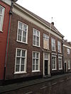 Huis met eenvoudige lijstgevel, ingang met witte pilasters