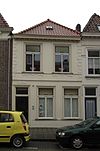 Huis met eenvoudige witgepleisterde lijstgevel en schilddak
