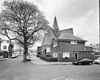 Exterieur overzicht van de kosterswoning, Drabbestraat 1, met daarachter de kerk - Bergen op Zoom - 20324325 - RCE -  Gereformeerde Kerk: Exterieur overzicht van de kosterswoning, Drabbestraat 1, met daarachter de kerk 