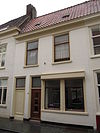 Huis onder zadeldak met gepleisterde lijstgevel