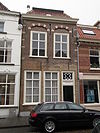 Huis met lijstgevel waarin geprofileerde tooglijsten op maskers plat dak