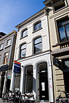 Monumentaal woonhuis met gepleisterde, deels gebosseerde, gevel met middenrisaliet en kroonlijst op zware consoles, onder zadeldak
