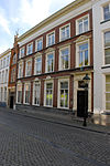 Groot huis, oorspronkelijk bestaande uit twee vleugels met voorhof, kort na 1848 uitgebouwd, maar nog in grote delen teruggaand tot de 15e eeuw. Kelders met tongewelven, ongewelfde kelderkeuken met zandstenen wangstukken van gotisch schouw. Voorgevel thans met uitvoerige vensteromlijstingen (frontons)