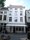Huis met eenvoudige gepleisterde verhoogde lijstgevel en zadeldak