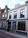 Pand met verdieping onder met rode hollandse pannen gedekt zadeldak tegen topgevel en met schild