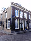 Huis met schilddak en eenvoudige lijstgevel in empire traditie, schuiframen, vensterluiken