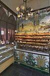 Interieur van de bakkerswinkel met toonbank en tegeltableaus - 's-Hertogenbosch - 20336773 - RCE -  Bakkerij: Interieur van de bakkerswinkel met toonbank en tegeltableaus (opmerking: Gepubliceerd in ANWB Monumentenboek Nederland, 2003) 