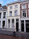 Huis met schilddak en gepleisterde lijstgevel waarin vensters met stucversiering uit omstreeks 1870